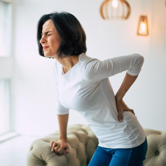 Image showing woman struggling to stand up due to lower back pain